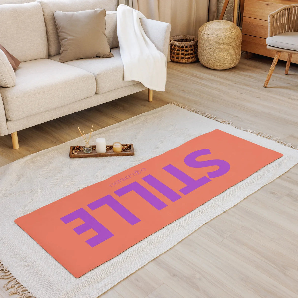 Yogamatte STILLE auf einem hellen Teppich im Wohnzimmer, Draufsicht mit lila Schriftzug