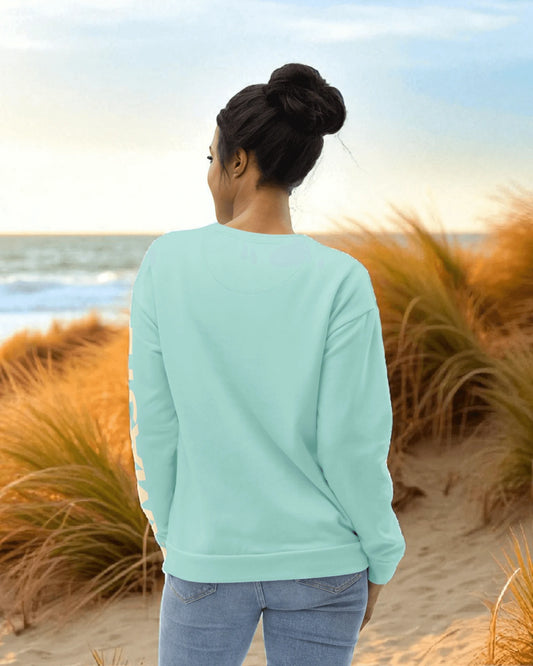 Goldsein-Sweater mit „Namaste“-Allover-Print am Strand – entspannter Wohlfühl-Lifestyle im Sonnenlicht.