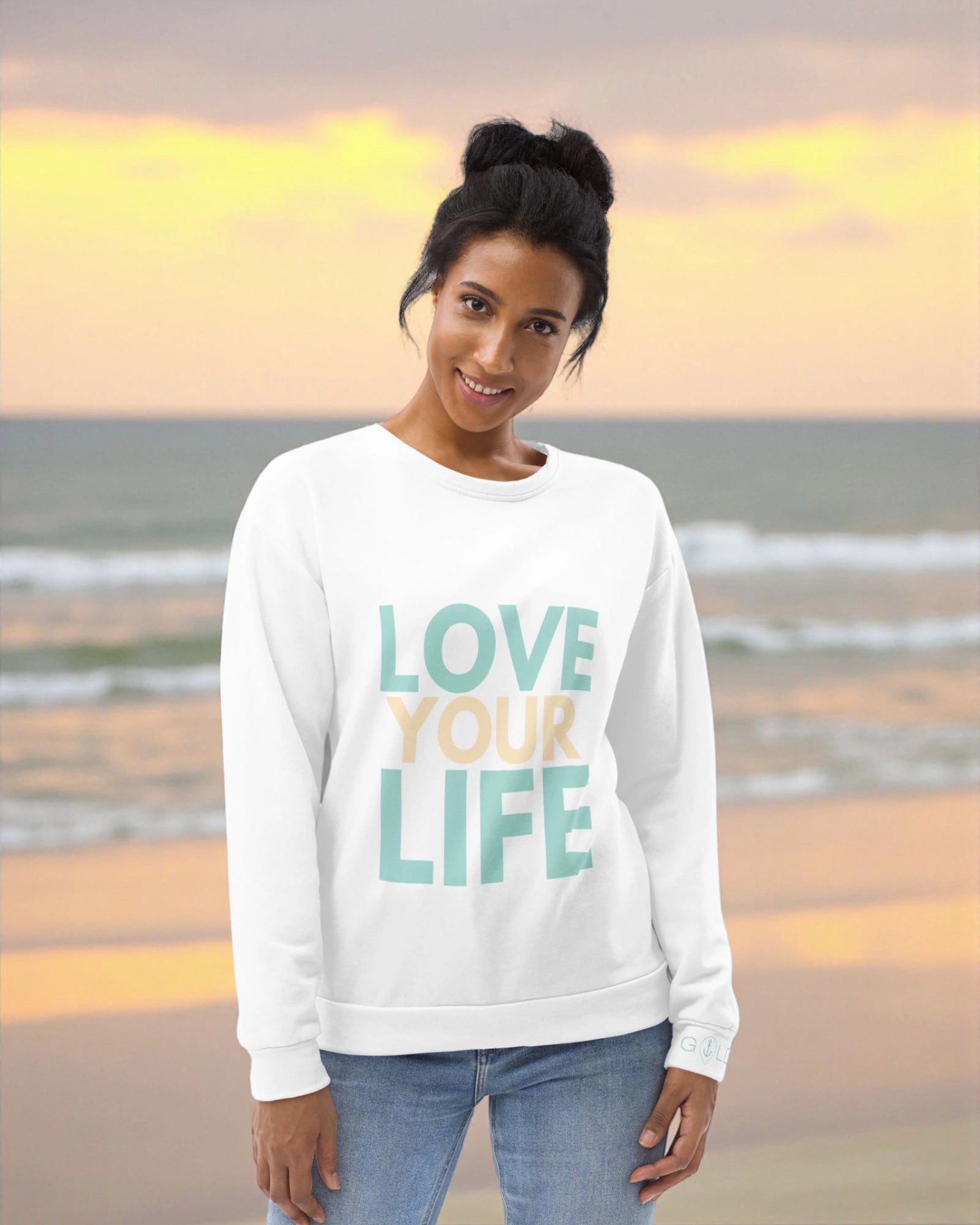 „Goldsein Woman Sweatshirt ‚Love Your Life‘ in Weiß, Türkis und Sand – schmeichelnd und lebendig.“