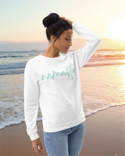 „Goldsein Woman Sweatshirt ‚Namaste‘ in Weiß-Türkis – entspannt, soft und bequem.“2